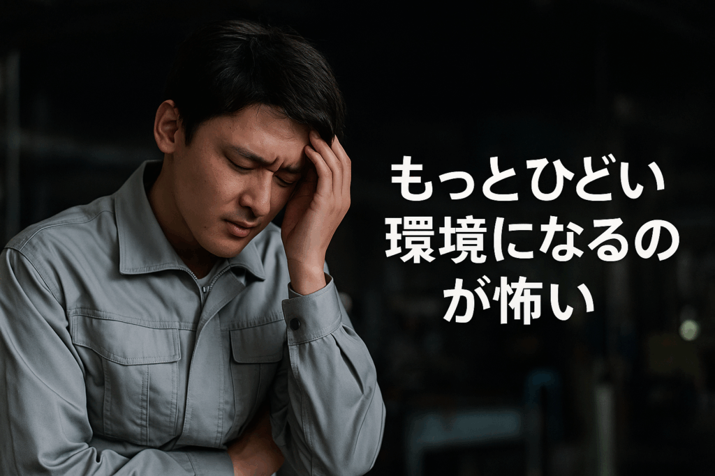 暗い工場内で作業服を着た若い男性が目を閉じて頭を押さえ、苦しそうな表情をしている